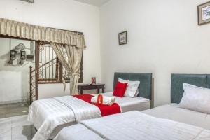 KalasanRedDoorz Syariah @ Raya Tajem Maguwo的一间卧室设有两张床和窗户。