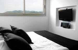 翁达Shhh酒店的一间卧室配有一张床和一台平面电视