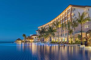 麦克坦Dusit Thani Mactan Cebu Resort的一座楼前有棕榈树的酒店