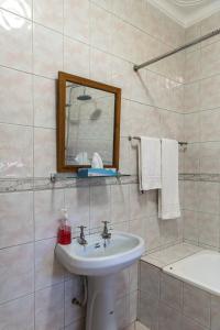 恩德培Muti Entebbe的浴室配有盥洗盆、镜子和浴缸