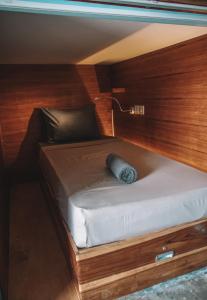 龙目岛库塔Kaniu Capsule Hostel的木墙客房内的小床