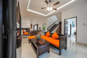 沙努尔Villa Rindik Sanur的客厅配有橙色沙发和吊扇