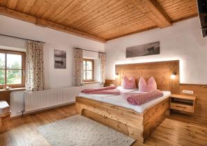 巴特霍夫加施泰因斯图博内巴酒店的卧室配有带粉红色枕头的大型木质床