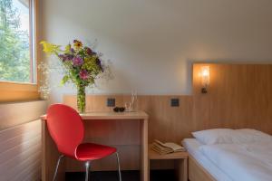 菲施Sport Resort Fiesch, Garni Aletsch的卧室配有红色椅子和花瓶
