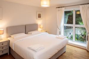 都柏林Baggotrath House Apartments, Newbridge Ave, Dublin 4的卧室设有一张白色大床和一扇窗户。