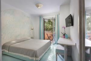 圣特雷莎加卢拉科拉拉洛酒店的一间卧室配有一张床、一张桌子和一个窗户。