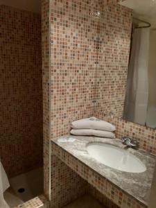 海尼夫拉HOTEL CONTINENTAL Khénifra的一间带水槽和镜子的浴室