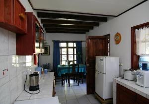马埃岛贝拉扎尔区拉罗卡尔酒店的厨房配有桌子和白色冰箱。