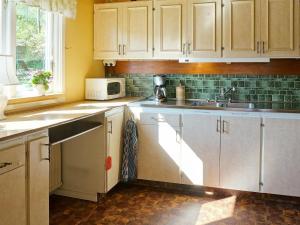 乌拉勒德6 person holiday home in ULLARED的厨房配有白色橱柜、水槽和微波炉