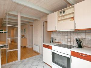 森讷维6 person holiday home in Ringk bing的厨房配有白色橱柜和梯子