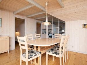 森讷维6 person holiday home in Ringk bing的一间带木桌和椅子的用餐室