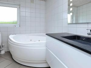 海默特Four-Bedroom Holiday home in Tarm 3的白色的浴室设有浴缸和水槽。
