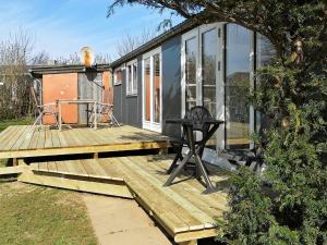 布罗艾厄4 person holiday home in Broager的坐在木甲板上的一个小房子