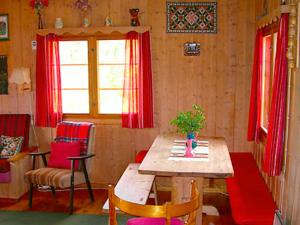 内斯比恩Three-Bedroom Holiday home in Nesbyen的用餐室配有木桌和红色窗帘