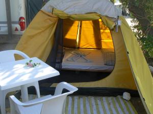 罗希姆诺伊丽莎白露营旅馆的黄色帐篷,配有一张床和一张桌子