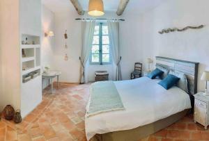 Saint-JulienLa Bastide的卧室配有带蓝色枕头的大型白色床