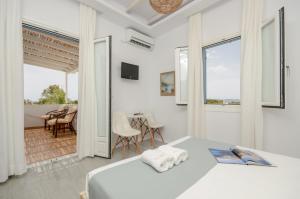 布拉卡Valena Mare Suites & Apartments的一间白色的卧室,配有床和用餐室