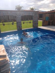 阿特利斯科Hotel Boutique Rincon Sagrado的两人在蓝色的大型游泳池游泳