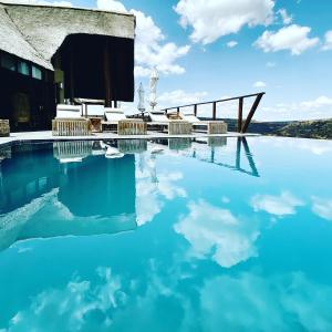 纳姆比提动物保护区Esiweni Luxury Safari Lodge的天上蓝色的海水和云的游泳池
