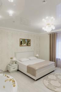 库尔斯克Отель "Даймонд Луговая"的白色卧室设有一张大床和浴缸