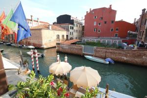 威尼斯东方魔力酒店的享有运河美景,设有两把遮阳伞和一艘船