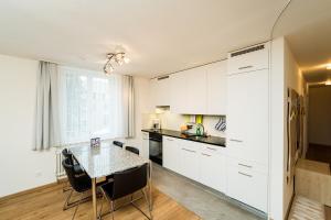 蓬特雷西纳Apartment Kesch Chesa Quadrella的厨房配有白色橱柜和桌椅