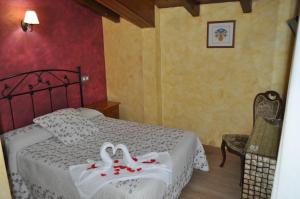 Los SantosCasa Rural Carpintero的一间卧室配有一张带两个天鹅的床
