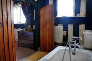 瓦伊河畔海伊雷德斯潘乡村民宿的带浴缸的浴室和木门。