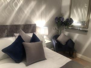 都柏林Beechtree House的一间卧室配有一张带蓝色枕头的床和一把椅子