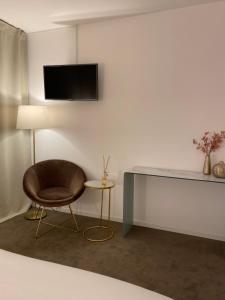 普里瓦尚米特酒店的一间带椅子和墙上电视的房间