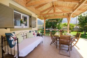 凯法利尼亚岛Sunnyside House Kefalonia的一个带床和木制凉亭的庭院