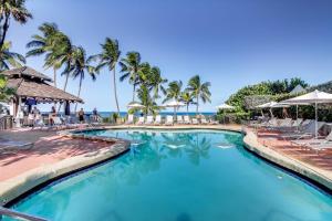 迈阿密海滩Inviting condo with pool & beach access的度假村的游泳池,配有椅子和棕榈树