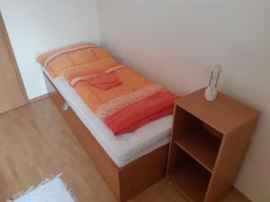 奥什恰德尼察Apartmán Borgi的一张小床,位于带床头柜的小房间