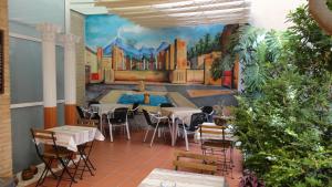 萨贡托B&B "Domus Atilia"的一间设有桌椅的房间和墙上的绘画
