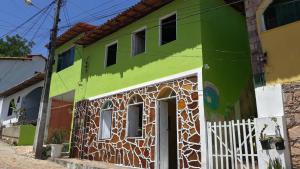 伦索伊斯Pousada Casa da Neuzita的街道上一扇白色门的绿色建筑