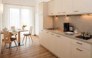 拉布拉Garni Appartment Wagnerhof的厨房配有白色橱柜、桌子和用餐室。