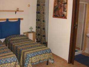 弗卢米尼马焦雷Centro di Turismo Equestre SHANGRILA'的酒店客房设有两张床和盥洗盆