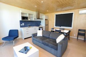 吉斯伯恩Waikanae Beach Ocean View Apartments的带沙发和桌子的客厅以及厨房。