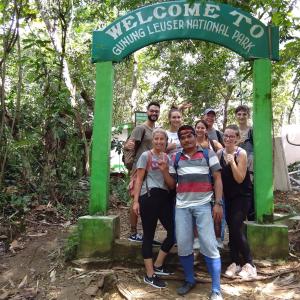 武吉拉旺Jungle treking & Jungle Tour booking with us的一群站在绿色标志下的人