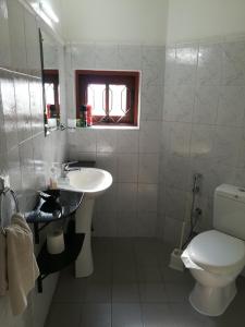 尼甘布阿玉波湾旅馆的白色的浴室设有卫生间和水槽。