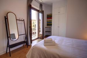 塞维利亚Apartamentos Setas Center的卧室配有白色的床和镜子