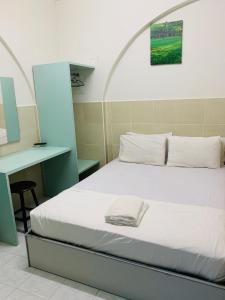 马六甲Fairway Hotel的一张位于带书桌和床的房间的床铺