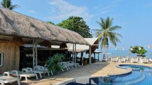 高兰Lanta New Coconut Bungalow的一个带游泳池和椅子的度假胜地和大海