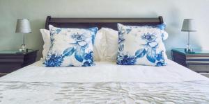 克拉伦斯8 Sleeper Villa and 4 Sleeper Flatlet的一间卧室配有一张带蓝色和白色枕头的床
