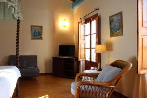 阿尔库迪亚Sant Jaume的一间卧室配有一张床、一把椅子和电视。