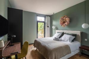 雷恩Maison Castellio by Cocoonr的一间卧室配有一张床、一张桌子和一个窗户。