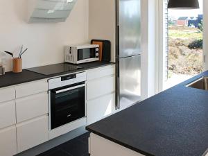 罗莫柯克比Four-Bedroom Holiday home in Rømø 11的厨房配有微波炉和冰箱。