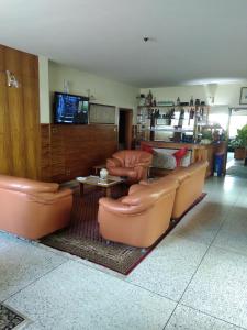 拉各斯曼努埃拉住宿酒店的客厅配有真皮座椅和电视
