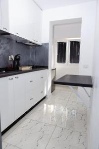 加拉茨Archi's Apartament的一间铺有大理石地板并配有白色橱柜的厨房