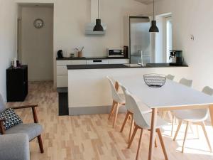 罗莫柯克比Four-Bedroom Holiday home in Rømø 11的厨房以及带白色桌椅的用餐室。